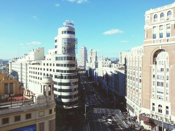 Traffic on street amidst buildings in city