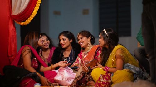 Friends sitting on sofa at home