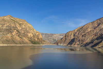 Scenic view of lake and mountains against blue sky