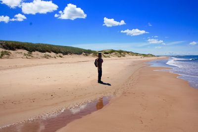 Scenic view of beach against blue sky