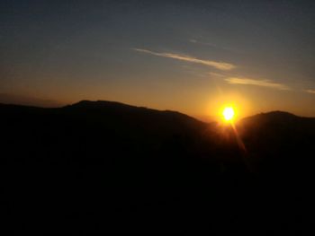 Scenic view of silhouette mountains against sky at sunset