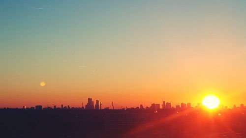 Silhouette buildings against sky during sunset