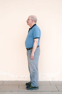 Portrait of young man standing against wall