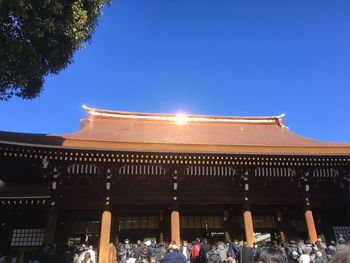 Group of people in front of building against blue sky