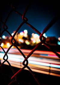 Close-up of illuminated chainlink fence at night