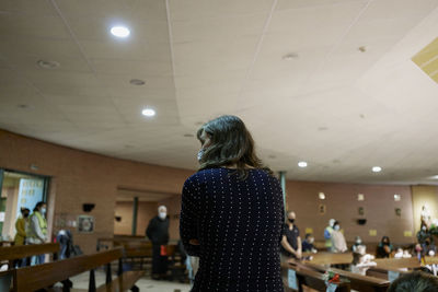 Woman with a group of people wearing medical mask inside a church