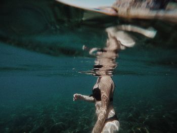 Rear view of woman swimming in sea