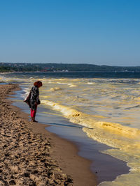 Full length of woman on beach against clear sky