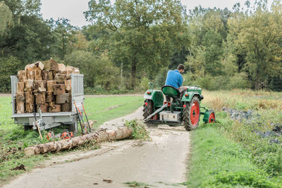 Rear view of farmer driving tractor at farm