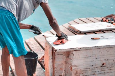 Midsection of man cutting fish