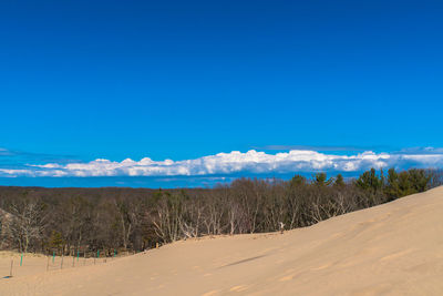 Panoramic view of desert against blue sky