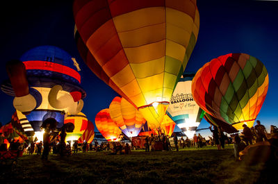 Low angle view of illuminated hot air balloons against sky
