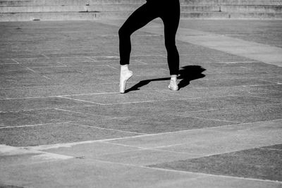 Low section of woman ballet dancer on footpath