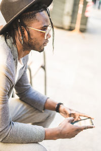 Young man looking away while sitting on camera