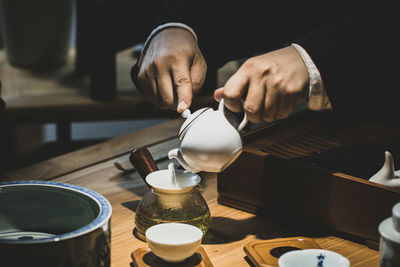 Close-up of hand pouring coffee in cup