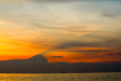 Scenic view of sea against dramatic sky during sunset