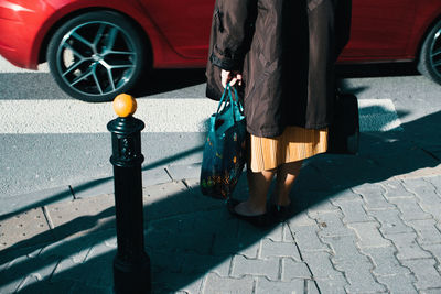 Low section of man standing on sidewalk