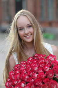 Portrait of beautiful young woman with red flower