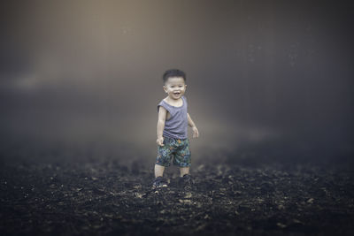 Portrait of cute baby boy standing on land in forest