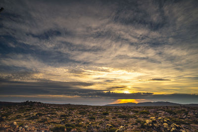 Scenic view of dramatic sky over landscape during sunset