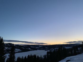 Scenic view of snowcapped mountains against clear sky during winter