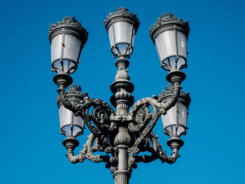 Low angle view of street light against blue sky