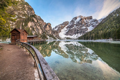 Scenic view of calm lake by mountains against sky