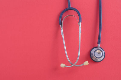 Close-up of stethoscope on red background
