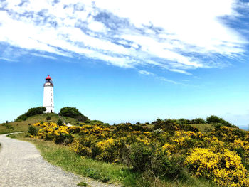 Lighthouse by sea against sky