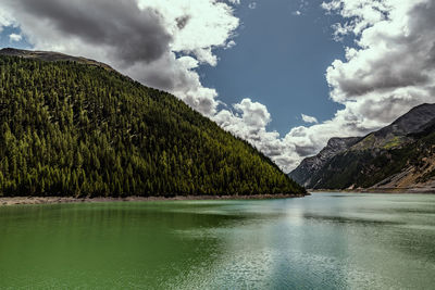 Scenic view of lake by mountains against sky