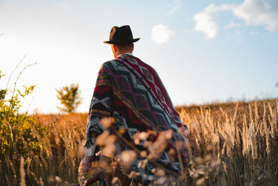 Man in poncho in a country field, atmospheric rural scene