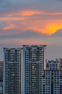 Modern buildings against sky during sunset