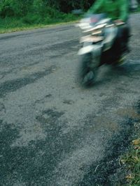 Blurred motion of people riding motorcycle on road in city