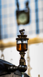 Close-up of illuminated lamp on table against wall