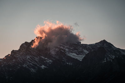 Smoke emitting from volcanic mountain against sky