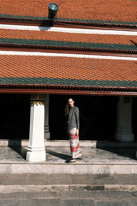 Rear view of woman standing against building