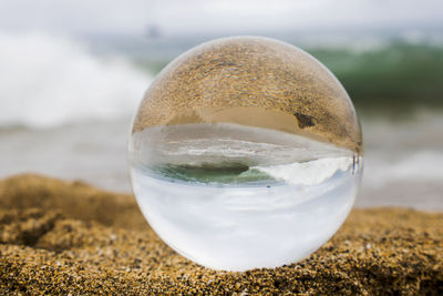 Close-up of glass of water on beach