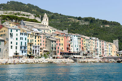 Buildings by sea against clear sky