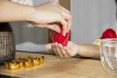 Close-up of people holding hands on table