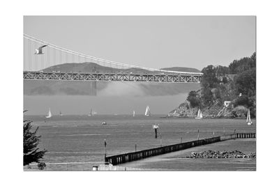 Bridge over sea against clear sky