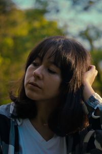 Close-up of sad woman sitting in park during sunset