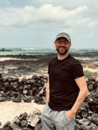 Portrait of young man standing at beach