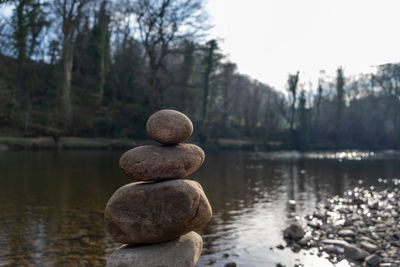 The top of a stack of balancing stones with a river in the background