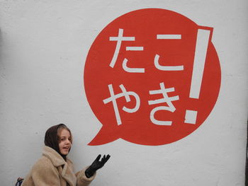 Portrait of girl with text against wall