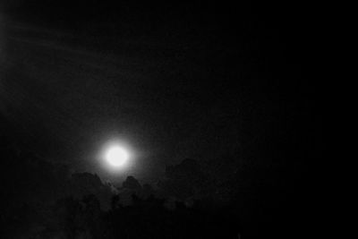 Low angle view of illuminated moon against sky at night