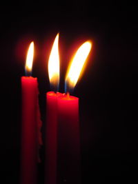 Close-up of lit candles in the dark