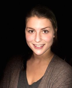 Portrait of smiling young woman against black background