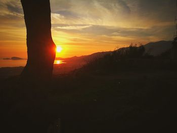 Silhouette landscape against sky during sunset