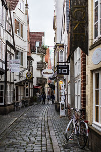 Bicycle parked on street amidst buildings in city