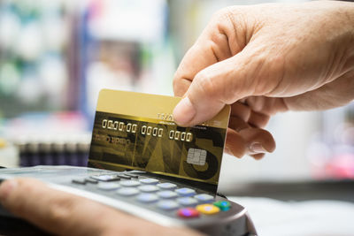 Close-up of hand swiping credit card